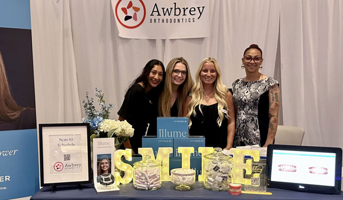 The Awbrey Orthodontics Team with a vendors table at a Community Event