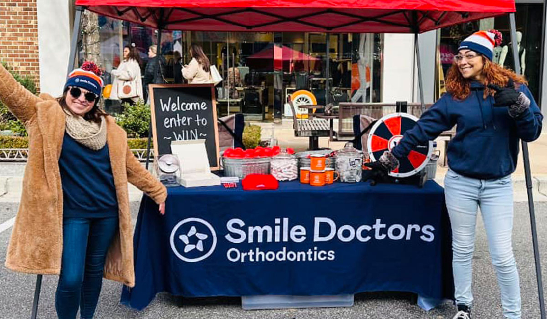 An image of the Awbrey Orthodontics Team with a vendors table at a Community Event